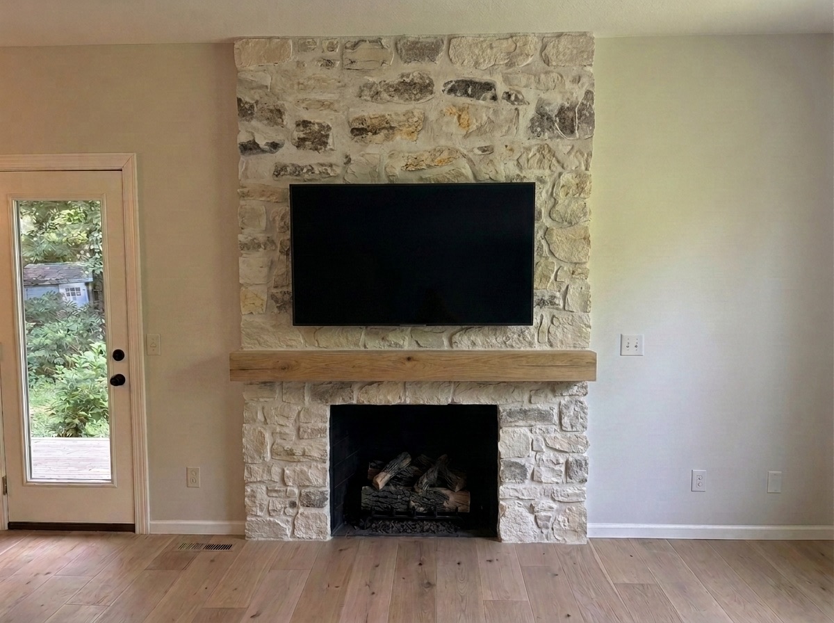 Same living room rendered finished: full natural-stone fireplace surround, chunky wood mantel, wide-plank wood floors