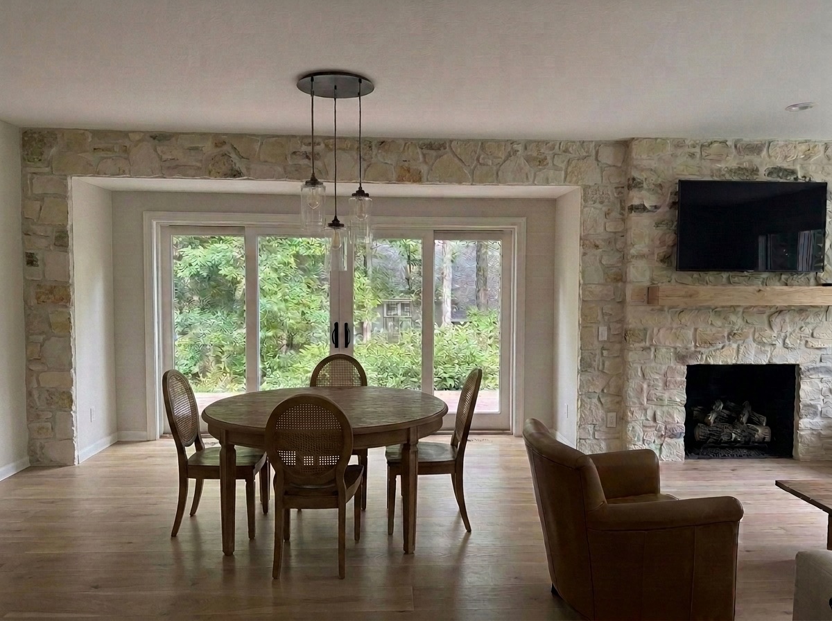 Great room rendered finished: bumped-out window wall, floor-to-ceiling stacked stone, wide-plank wood floors